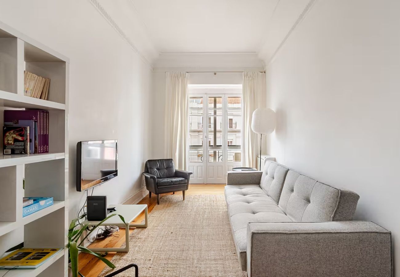 Sala de estar com sofá confortável, decoração minimalista e varanda luminosa