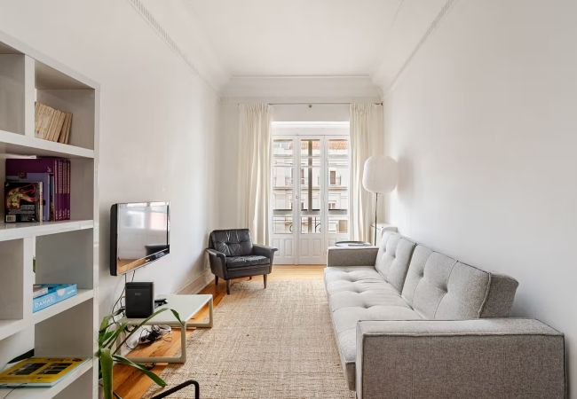 Elegant living room with a comfortable sofa, minimalist decor and a bright balcony.